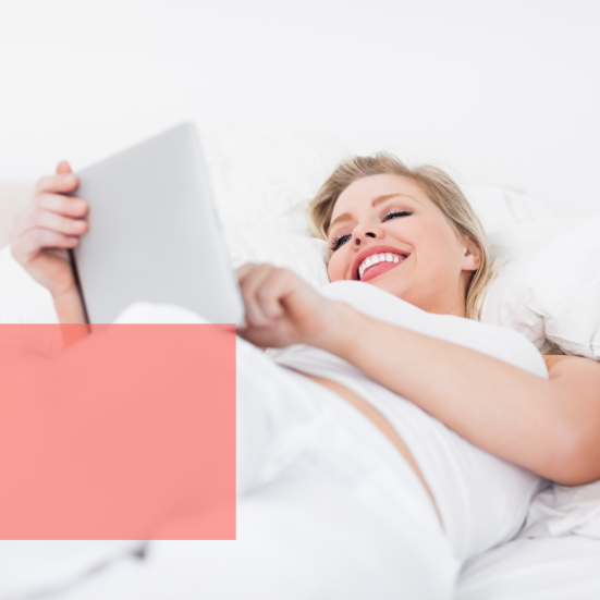 Kvinde læser og grinder i seng