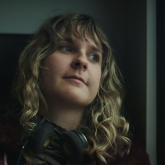 Kvinde sidder i tog og kigger eftertænksomt