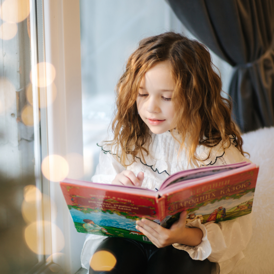 Pige, der læser en stor bog