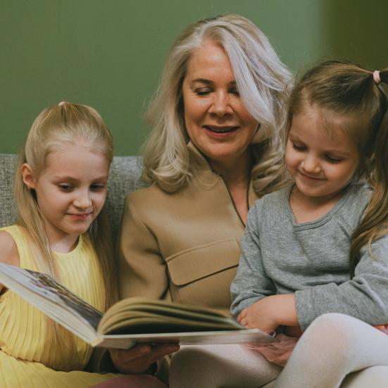 Kvinde læser højt for to piger