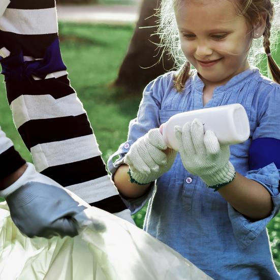 Pige og dame samler skrald i stor sæk