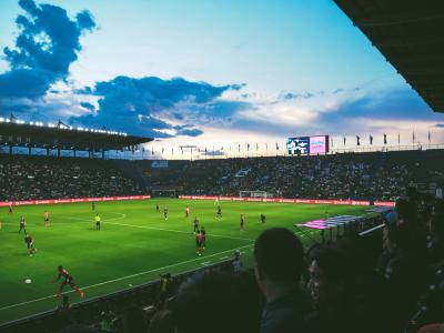 Fodboldbane med spillere i aftenlys