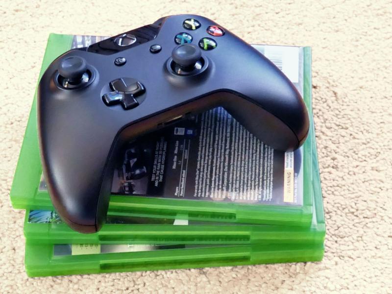 Xbox controller oven på tre xboxspil med bagsiden opad