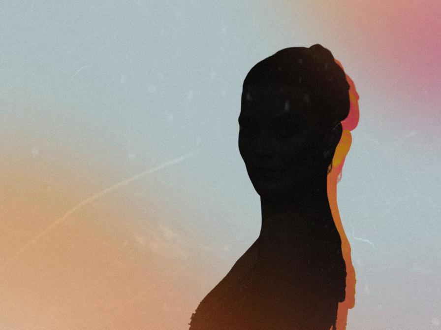 Mørk silhuet af skuespilleren Margot Robbie med farvet kantlys foran en pastelfarvet himmel.