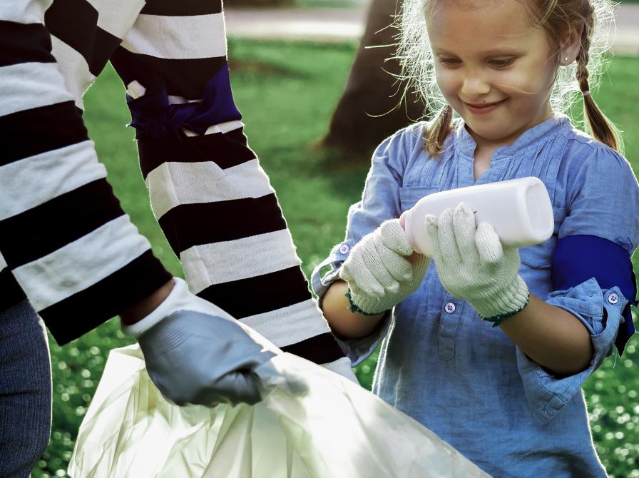 Pige og dame samler skrald i stor sæk
