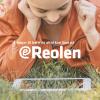 Børn læser en på en mobiltelefon, liggende i græsset
